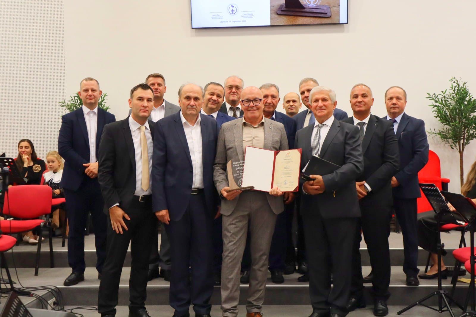 Frații slujitori și invitații la serviciul divin aniversar din 14 septembrie 2025; unul dintre ei ține o diplomă.